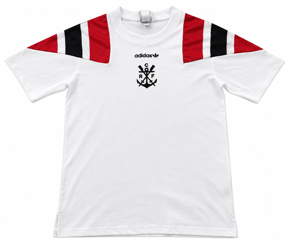 Frente de la camiseta blanca del Flamengo con hombros rojo y negro, trébol de Adidas y el emblema del ancla con CRF
