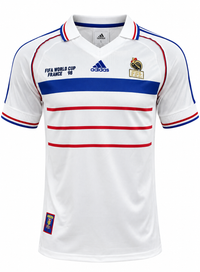 Frente de la camiseta blanca visitante de Francia 1998, con franjas rojas al pecho, vivos azules y el gallo dorado de la FFF