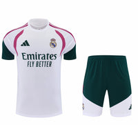Camisa branca de treino do Real Madrid com ombros rosa e verde e Emirates, ao lado do calção verde e branco