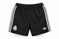 Pantaloneta negra del Real Madrid con tres rayas blancas y trébol, escudo y el trébol de Adidas