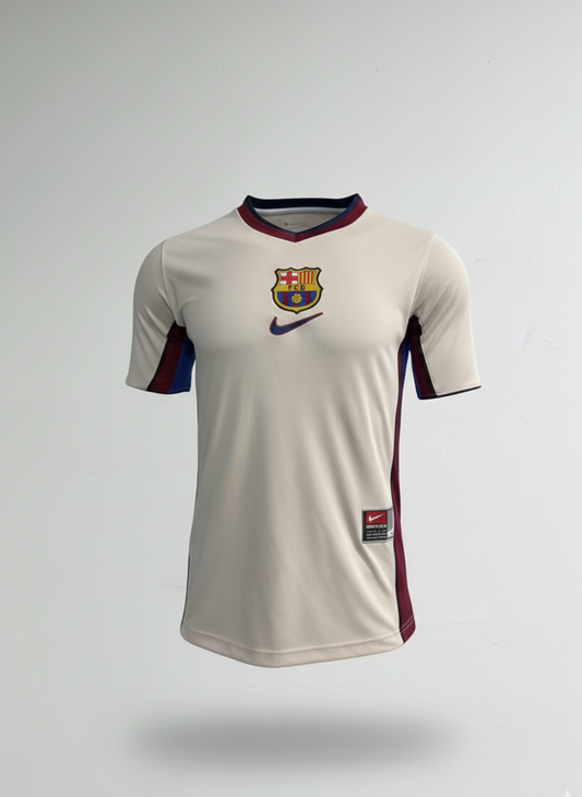 Camiseta de visitante FC Barcelona temporada 1998/99, color gris plata con franjas azulgranas centrales, tela técnica retro y escudo bordado.