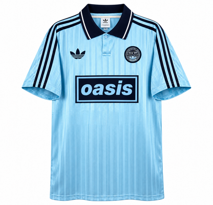 Camisa celeste Oasis x Adidas Tour 3 Rayas, com gola e listras em azul-marinho e a caixa do logo Oasis em azul-marinho no peito