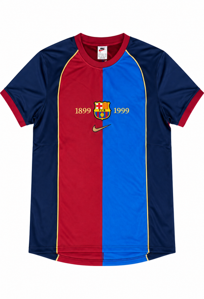 Camiseta del FC Barcelona partida en granate y azul, con las fechas 1899 y 1999 en dorado y el escudo del club al centro