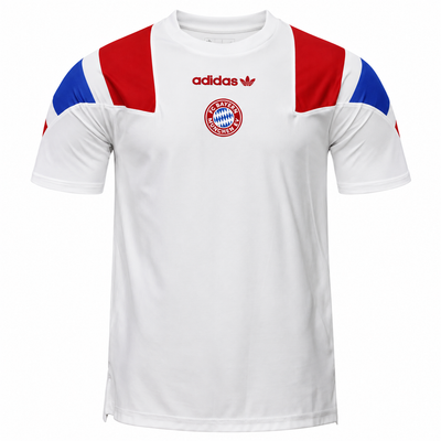 Frente de la camiseta blanca del Bayern Múnich con hombros rojo y azul, trébol de Adidas en rojo y escudo redondo