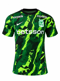 Frente de la camiseta de calentamiento Nike 2026 del Atlético Nacional, verde con manchas verde neón, Postobón en los hombros y betsson en el pecho
