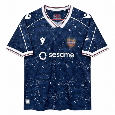 Frente de la camiseta azul marino del Levante cuarta 2026-27 con salpicado blanco, cuello en V y patrocinador sesame