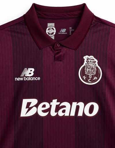 Detalle del cuello polo de la camiseta del Porto visitante 2026/2027, con el sello Porto 1893 Invicta por dentro