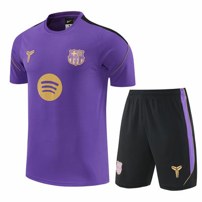 Camiseta morada de entrenamiento del Barcelona con escudo y Spotify en dorado, junto a la pantaloneta negra con franja morada
