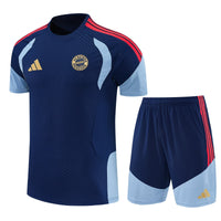 Camiseta azul oscuro de entrenamiento del Bayern Múnich con paneles celestes y tres franjas rojas, junto a la pantaloneta del mismo juego