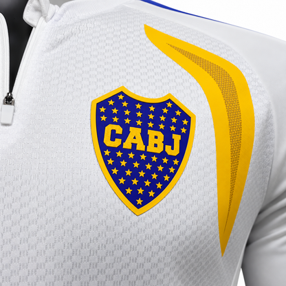 Escudo azul de Boca Juniors con estrellas y borde amarillo, al pecho del fleece blanco
