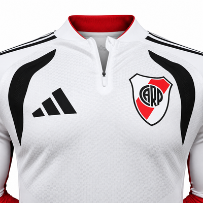 Detalle del pecho del fleece blanco de River Plate, con el escudo y las tres barras de Adidas en negro