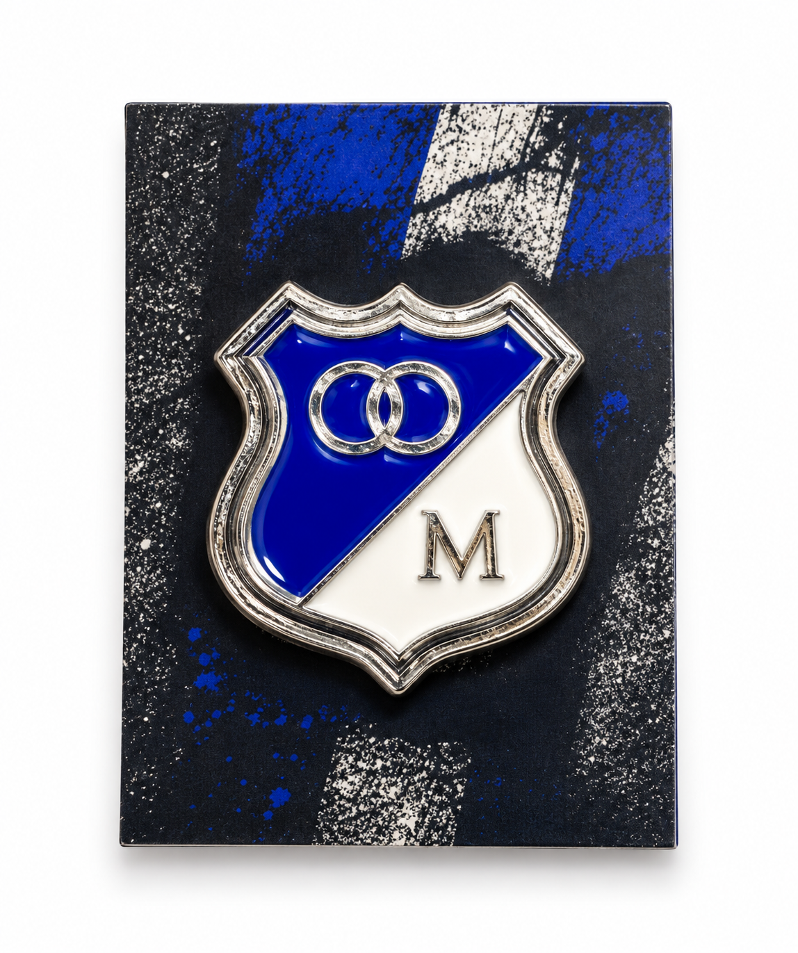 Llavero de Millonarios con el escudo clásico azul y blanco de la M, en su tarjeta oscura