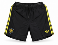 Black and yellow Manchester United shorts with three yellow stripes, the crest and the Adidas trefoil