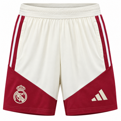 Pantaloneta crema del Real Madrid con paneles vinotinto abajo, tres rayas a los lados, escudo y logo de Adidas