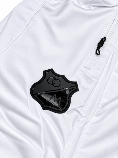 Detalhe do escudo preto do Millonarios e do bolso com zíper do agasalho branco